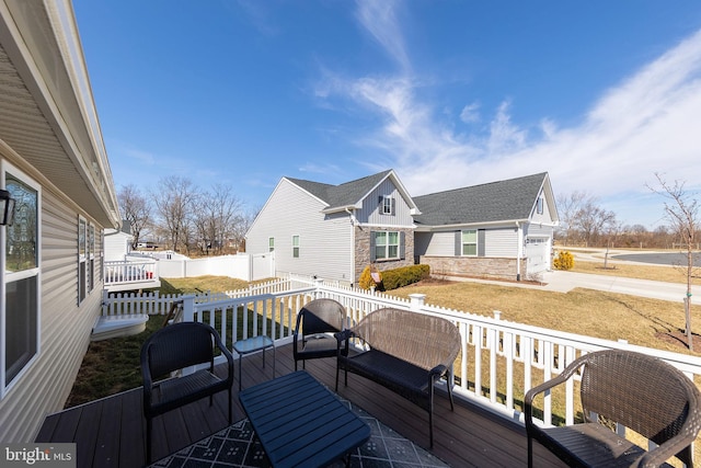 wooden terrace with driveway, a residential view, and fence