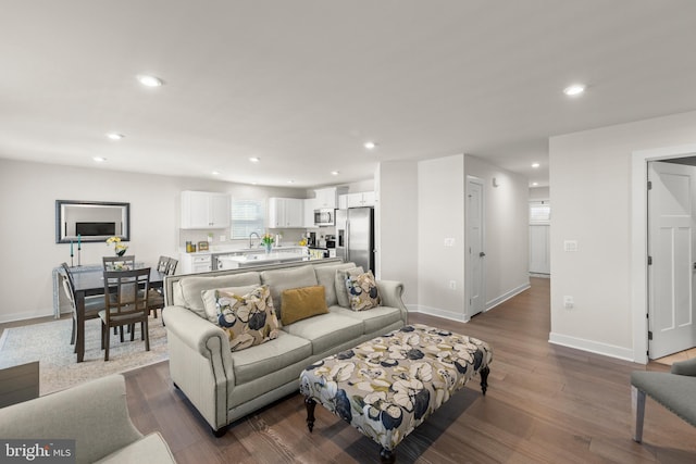 living area featuring baseboards, dark wood finished floors, and recessed lighting