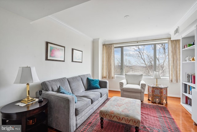 living room with baseboards, ornamental molding, and wood finished floors