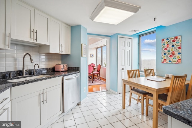 kitchen with visible vents, decorative backsplash, stainless steel dishwasher, a sink, and light tile patterned flooring