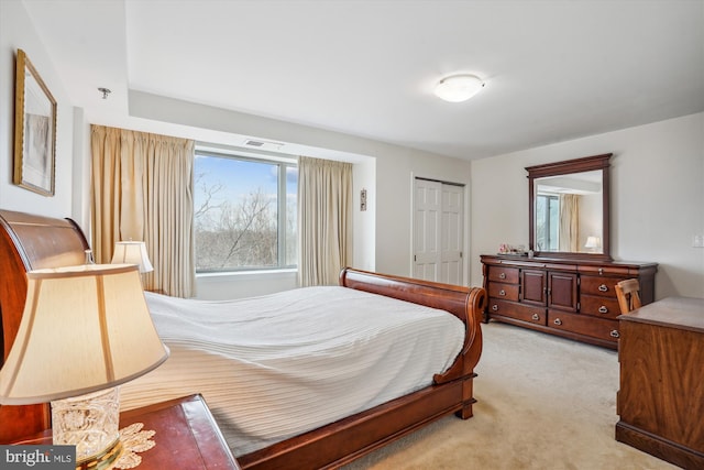 carpeted bedroom with a closet and visible vents