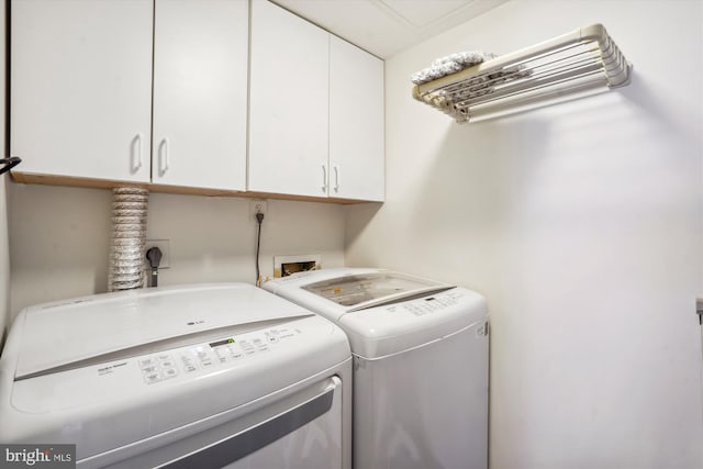 washroom featuring cabinet space and washer and clothes dryer