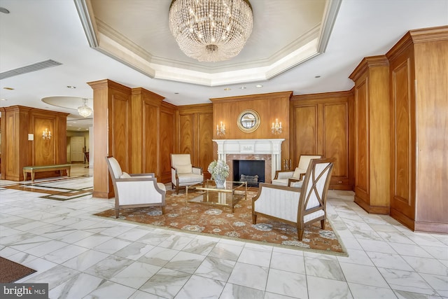 sitting room with marble finish floor, a raised ceiling, visible vents, a premium fireplace, and ornamental molding