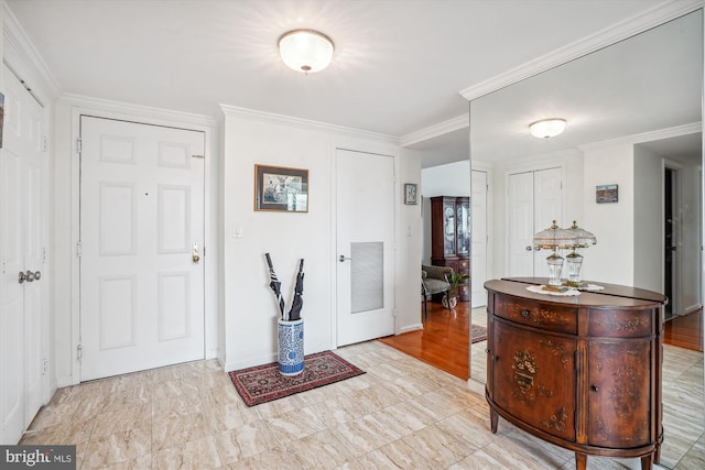 entryway with baseboards, visible vents, and crown molding