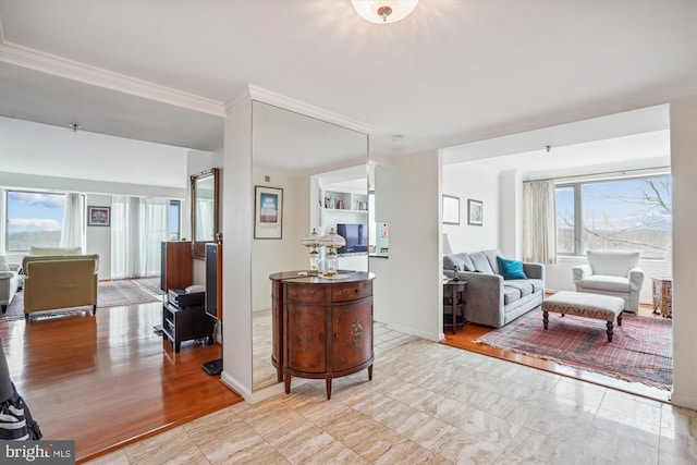 interior space with baseboards, crown molding, and wood finished floors