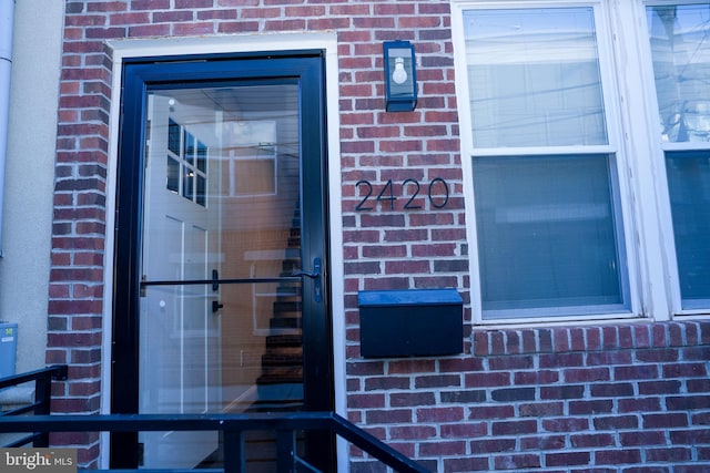 view of exterior entry with brick siding