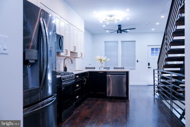 kitchen with stainless steel appliances, light countertops, dark wood-type flooring, a sink, and dark cabinets