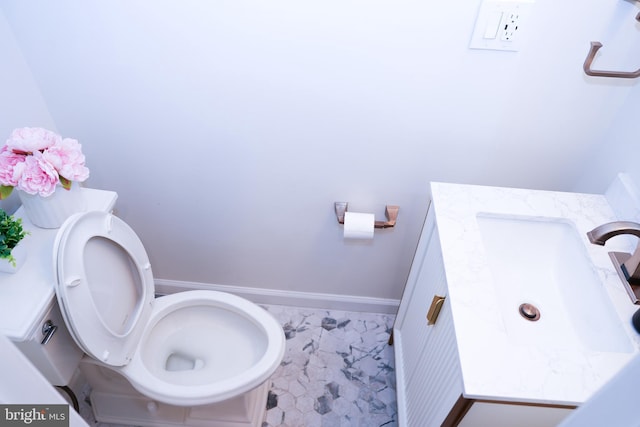 bathroom with vanity, toilet, and baseboards