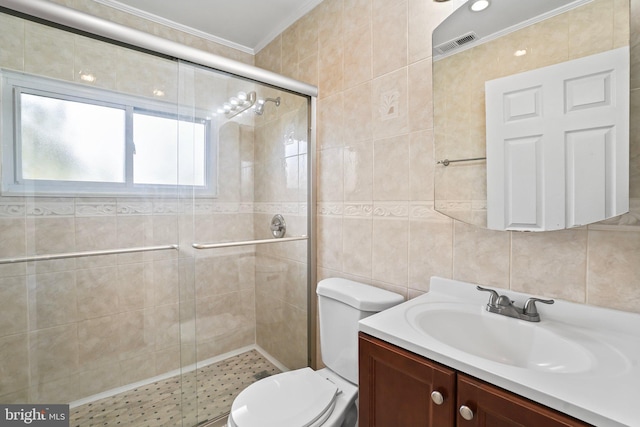 full bathroom featuring visible vents, toilet, ornamental molding, a shower stall, and tile walls