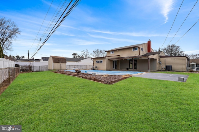 view of yard featuring an outbuilding, a patio, a storage unit, cooling unit, and a fenced backyard