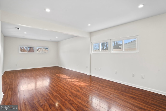 empty room with dark wood-style floors, baseboards, and recessed lighting