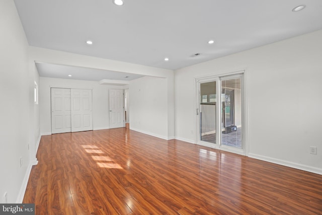 interior space with access to outside, wood finished floors, and baseboards