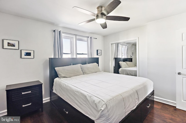 bedroom with dark wood-style floors, ceiling fan, and baseboards