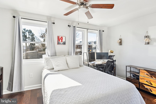 bedroom with a ceiling fan, baseboards, and dark wood-style flooring