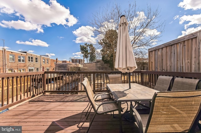 wooden terrace with a residential view and outdoor dining space