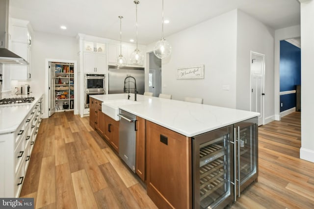 kitchen featuring glass insert cabinets, brown cabinetry, white cabinetry, and a large island with sink