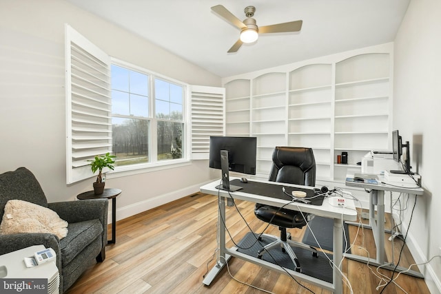 office space featuring a ceiling fan, baseboards, and wood finished floors