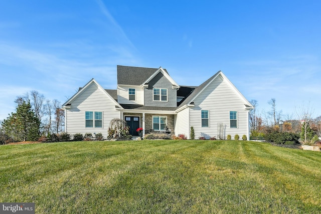 view of front of home with stone siding and a front lawn