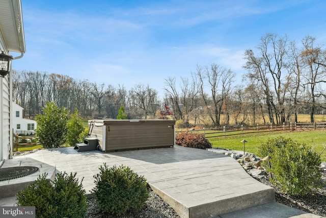 exterior space with a lawn, a jacuzzi, fence, and a patio