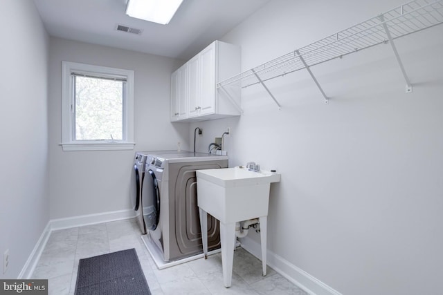 laundry area featuring baseboards, visible vents, cabinet space, and washer and clothes dryer