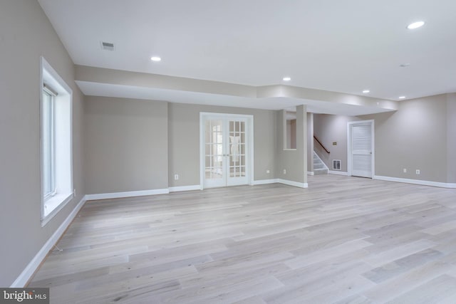 basement featuring recessed lighting, baseboards, stairway, and light wood-style floors