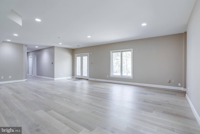 spare room with recessed lighting, baseboards, and light wood-type flooring