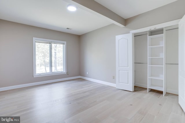 unfurnished bedroom featuring baseboards, visible vents, and light wood-type flooring