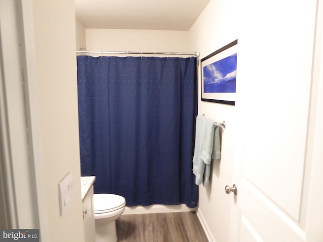 bathroom with vanity, curtained shower, wood finished floors, and toilet