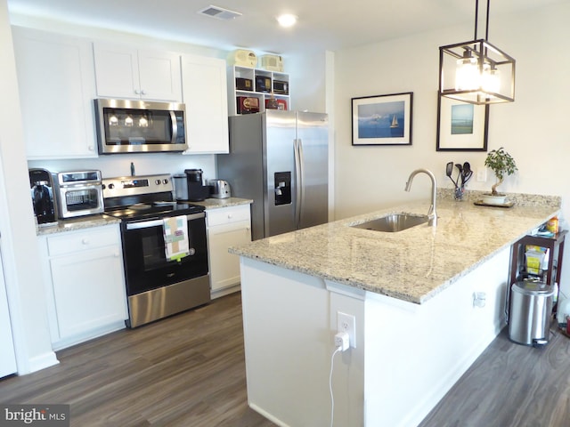 kitchen featuring white cabinets, appliances with stainless steel finishes, a peninsula, hanging light fixtures, and a sink