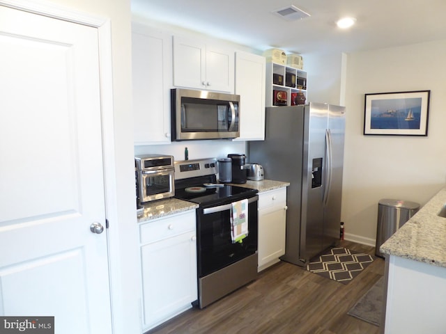 kitchen with white cabinets, visible vents, stainless steel appliances, and light stone counters