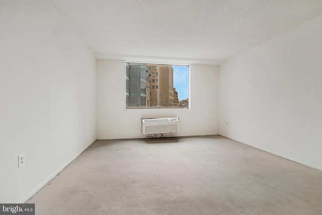 spare room with unfinished concrete floors and a wall mounted AC