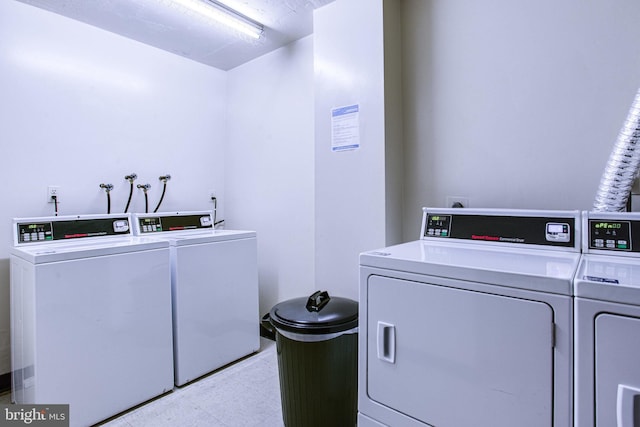 shared laundry area with light floors and separate washer and dryer