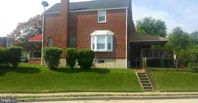 view of home's exterior with brick siding, a lawn, a chimney, and stairs