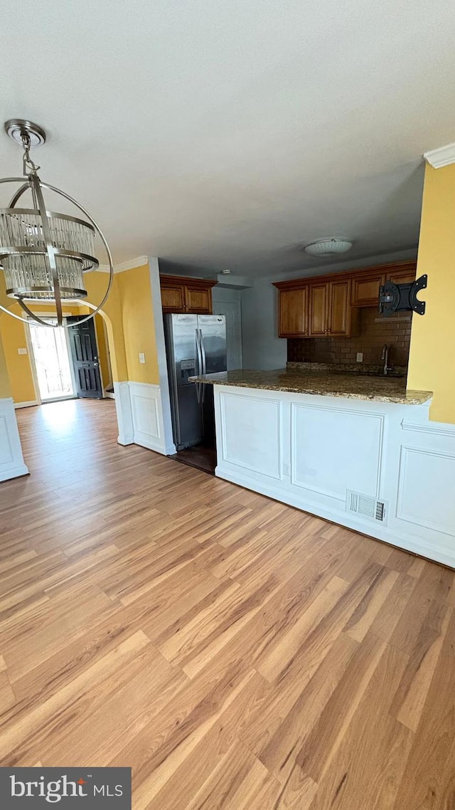 5716 Willowton Ave, Baltimore, MD 21239 - kitchen with visible vents, stainless steel refrigerator with ice dispenser, a chandelier, and light wood-style floors