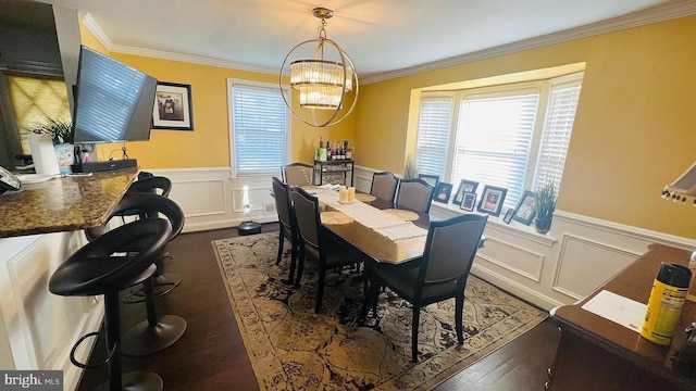 dining space with a wainscoted wall, a notable chandelier, and crown molding