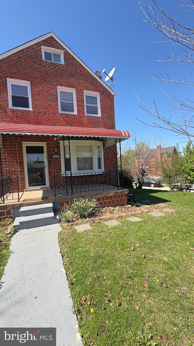 5716 Willowton Ave, Baltimore, MD 21239 - view of front of home featuring brick siding, a front yard, and covered porch
