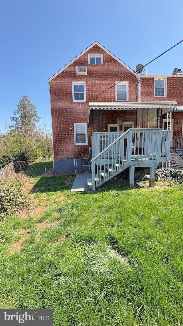 5716 Willowton Ave, Baltimore, MD 21239 - rear view of property featuring brick siding, fence, a patio area, and a lawn