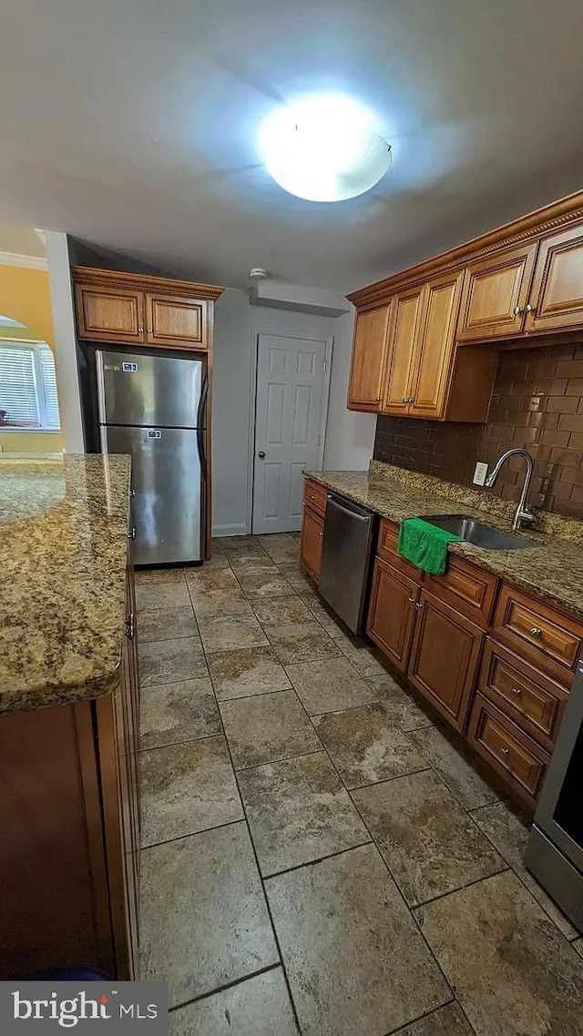 5716 Willowton Ave, Baltimore, MD 21239 - kitchen featuring backsplash, light stone countertops, brown cabinets, appliances with stainless steel finishes, and a sink
