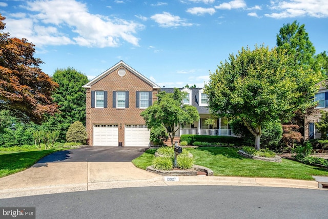 view of front of property with a garage, brick siding, aphalt driveway, a porch, and a front yard