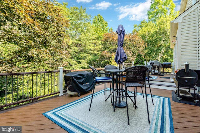 wooden deck with outdoor dining space and a grill