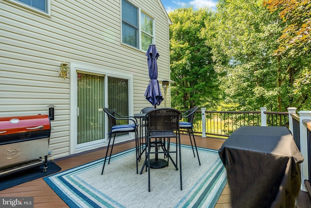 deck with outdoor dining area and grilling area