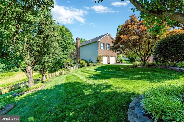 view of yard featuring a garage and fence