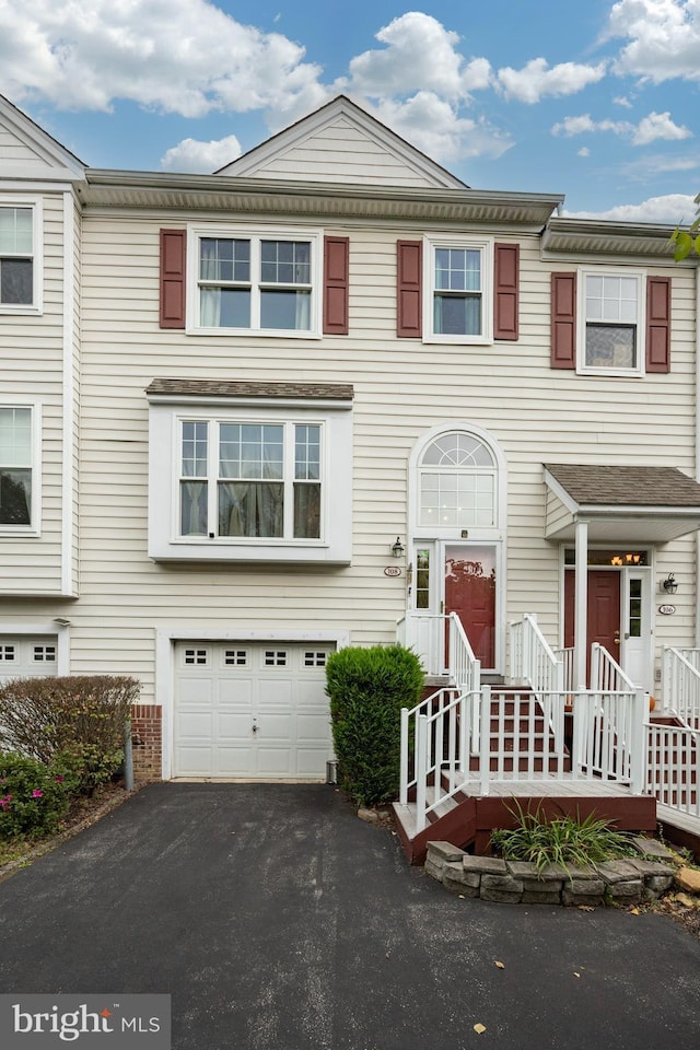 multi unit property featuring a garage and aphalt driveway