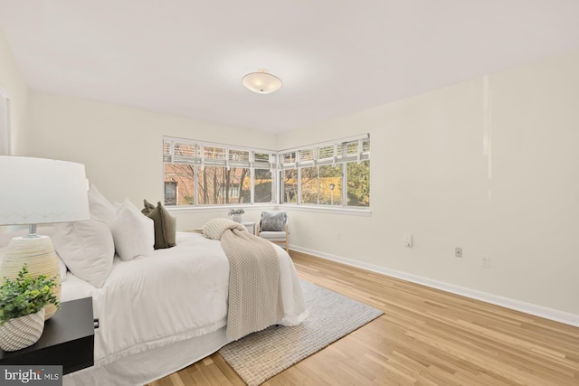 bedroom with baseboards and wood finished floors