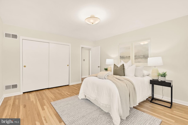 bedroom featuring light wood-type flooring, visible vents, and baseboards