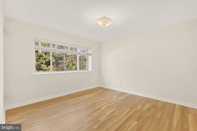 empty room featuring light wood-style flooring and baseboards