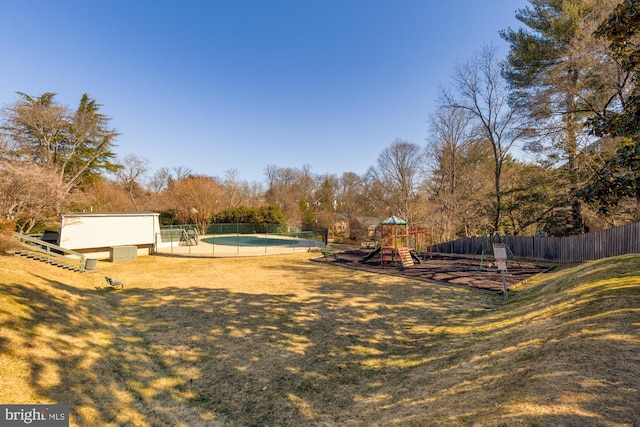 view of yard featuring a playground, fence, and a fenced in pool