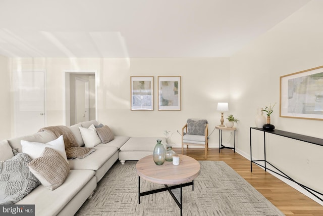 living area with baseboards and wood finished floors