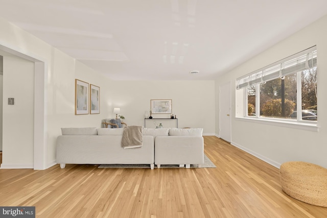 living area with baseboards and light wood finished floors