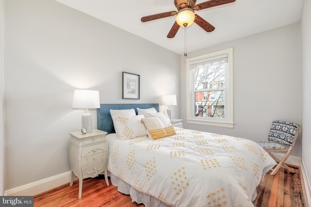 bedroom with ceiling fan, baseboards, and wood finished floors